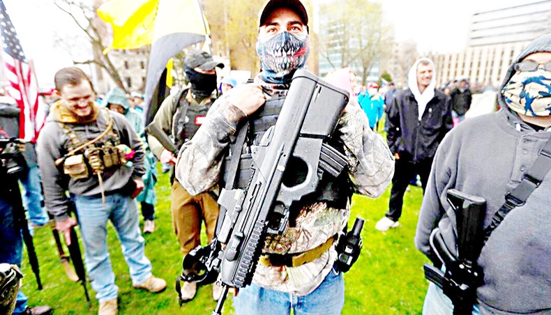 A protester carry his rifle at the state Capitol in Lansing, Michigan. — The Associated Press/Paul Sancya