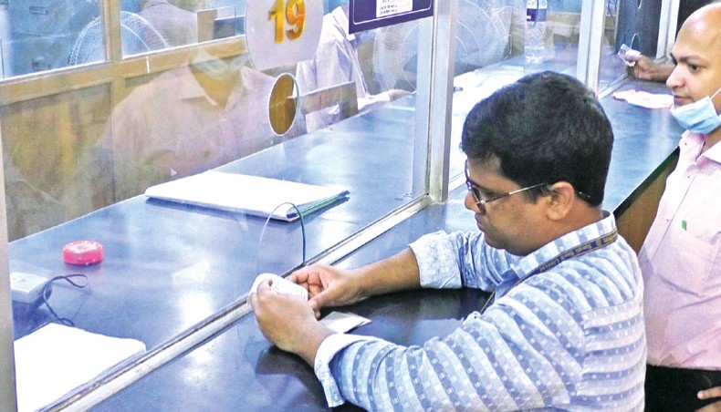 Clients without wearing face masks receive services at a branch of a state-owned bank in Dhaka on Wednesday while experts fear an onslaught of second wave of coronavirus infections. — Abdullah Apu