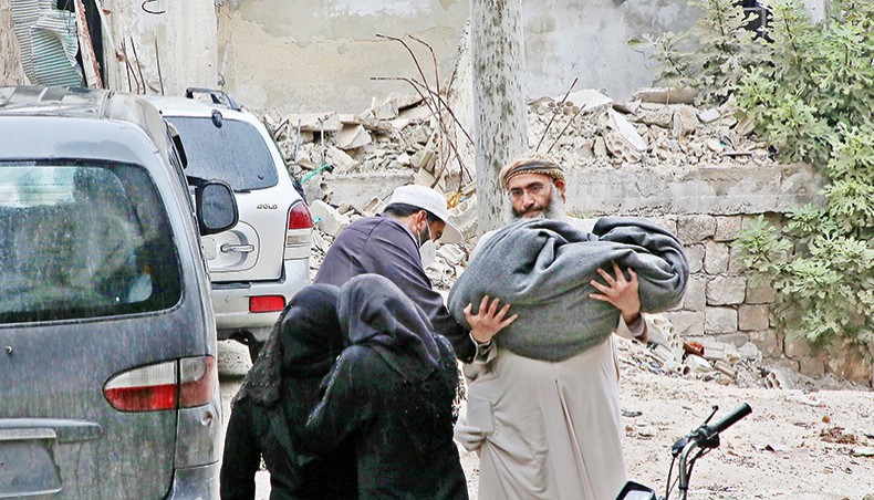 A Syrian man carries the body of a child killed in early morning shelling on the town of Ariha by government forces in the rebel-held area in northwestern Syria early on Wednesday. — AFP photo