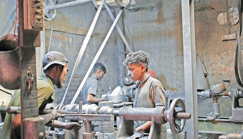 Underage labourers work in an aluminum utensil factory at Keraniganj in Dhaka without taking necessary precautions and safety measures, exposing themselves to metal dust and the novel coronavirus. — Sourav Lasker