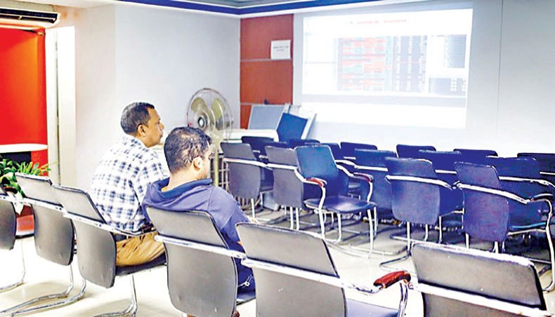 A file photo shows investors looking at share price movements on a screen at a brokerage house in the capital. Dhaka stocks declined for the second day on Thursday as investors remained cautious amid worries over mutual funds following the formation of a committee by the Bangladesh Securities and Exchange Commission to investigate an abnormal surge in unit prices of five MFs.— New Age photo