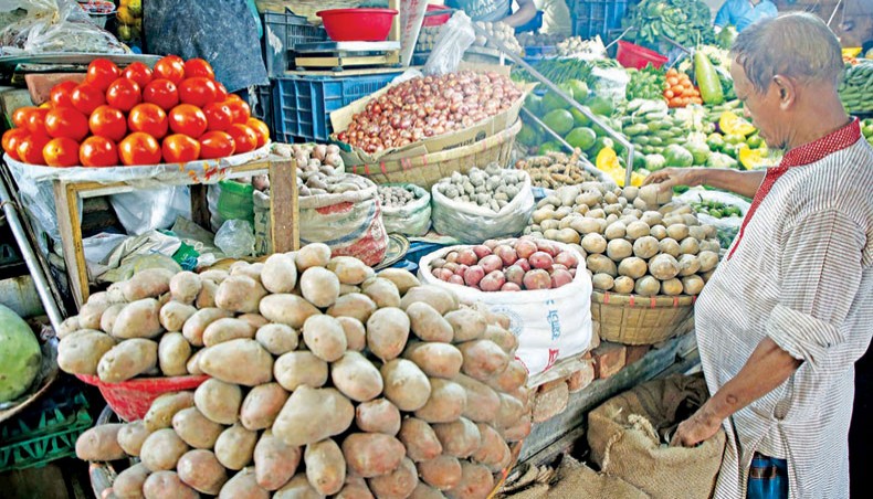 A file photo shows a man looking at potatoes at a kitchen market in the capital last week. The price of potato increased on the city’s kitchen markets over the week ending on Friday due to a supply shortage of the item. — New Age photo