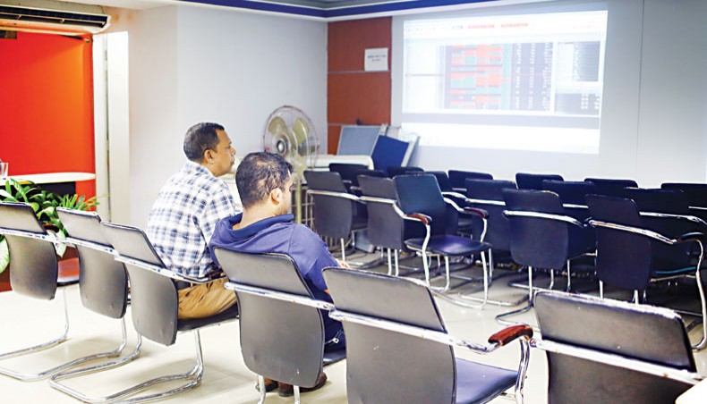 A file photo shows investors looking at share price movements on a screen at a brokerage house in the capital. Dhaka stocks last week dropped for the second week as investors went for selling shares amid the subscription of the initial public offering of the country’s second largest mobile company, Robi.— New Age photo