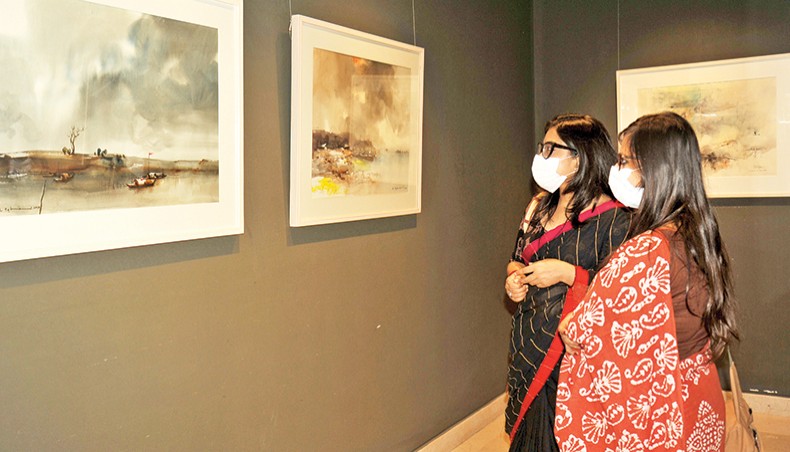 Visitors look at paintings at a group art exhibition titled Jolokabya-3 under way at Edge Gallery in Gulshan, Dhaka. — Press release