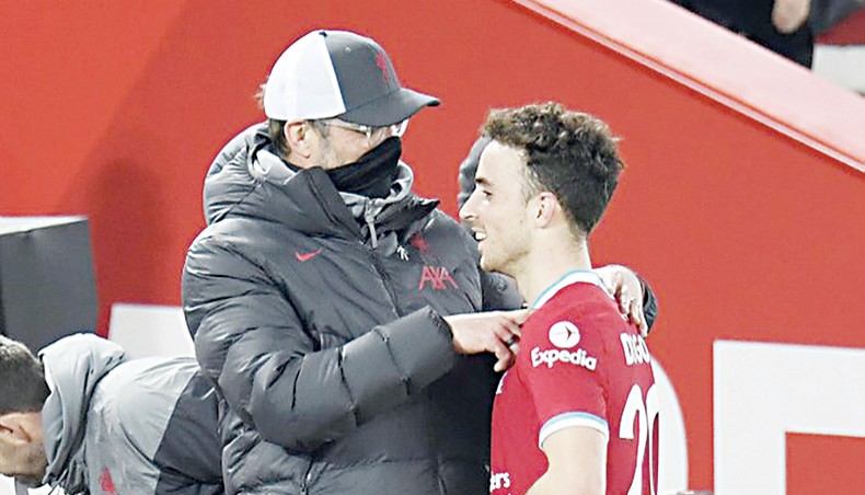 Liverpool’s manager Jurgen Klopp (L) talks to striker Diogo Jota as the player is replaced during their Premier League match against Leicester City at Anfield on Sunday. — AFP photo