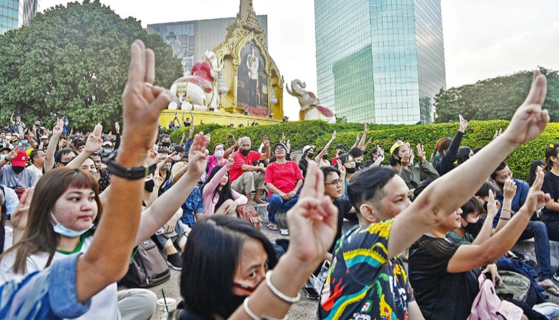 Pro-democracy protesters give the three-finger salute during an anti-government rally outside the headquarters of the Siam Commercial Bank in Bangkok on Wednesday. — AFP photo