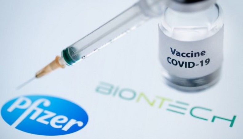 This illustration picture taken on November 23, 2020 shows a bottle reading ‘Vaccine COVID-19’ and a syringe next to the Pfizer and Biontech logo.- AFP photo