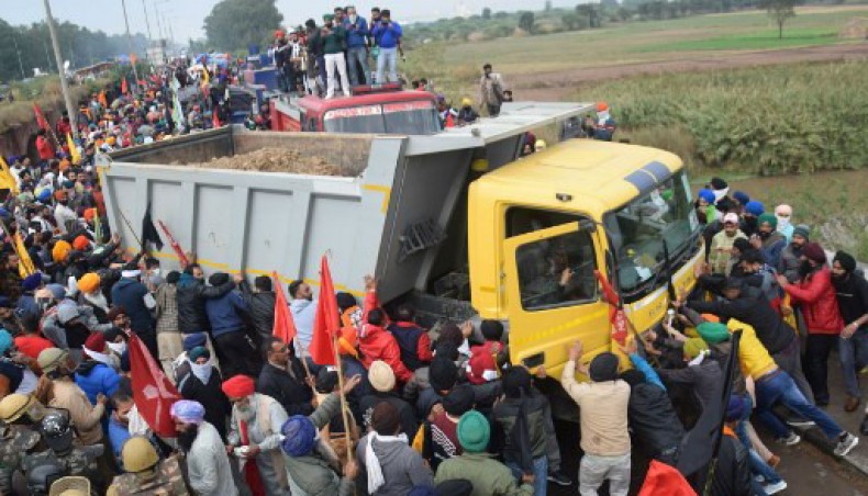 Farmers push a truck blocking a road during a march to India's capital New Delhi to protest against the central government's recent agricultural reforms, in Ambala on November 26, 2020.- AFP photo