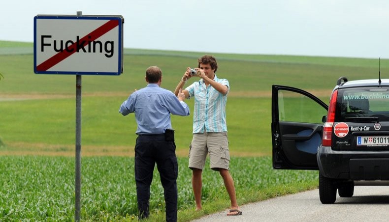 This file photo taken on June 18, 2008 shows tourists taking pictures of the road sign of the village of Fucking, some 35 km North of Salzburg, Austria. -- AFP photo