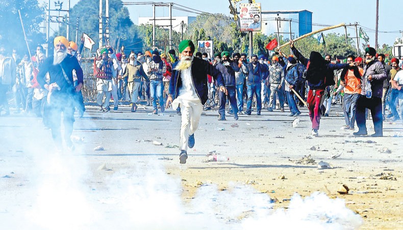 Police fire tear gas to disperse farmers at a roadblock as they try to march to New Delhi to protest against the central government’s recent agricultural reforms at the Delhi-Haryana border in Kundli on Friday. — AFP photo