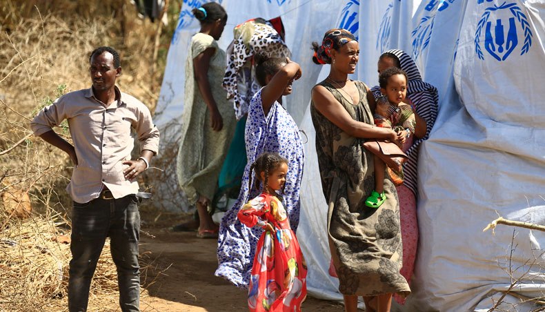 Ethiopian refugees, who fled the Tigray conflict, stand in the shade of a tent at Um Raquba camp in Sudan’s eastern Gedaref province on November 28, 2020. — AFP photo