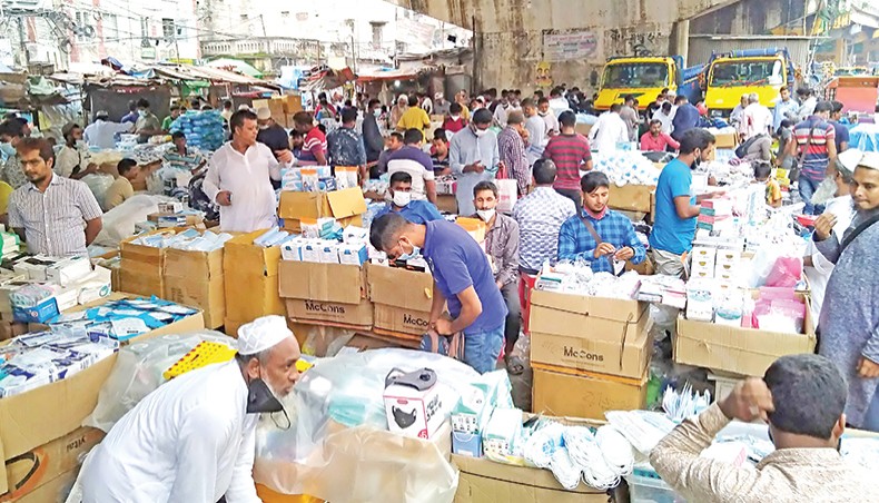 Traders mostly without masks sell masks in makeshift shops under Babu Bazar Bridge in Dhaka on Monday. — Sourav Lasker