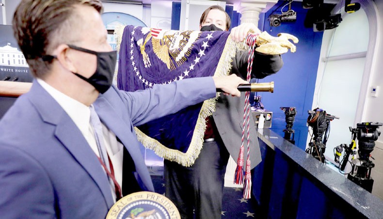 Members of the White House communications staff take down the presidential flag after US president Donald Trump made a brief statement to reporters in the James Brady Press Briefing Room at the White House on November 24 in Washington, DC. — Agence France-Presse/Getty Images/Chip Somodevilla