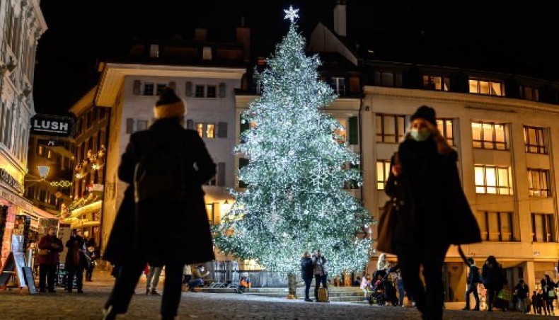 People walk past a Christmas tree in the centre of Lausanne on December 17, 2020. - AFP photo