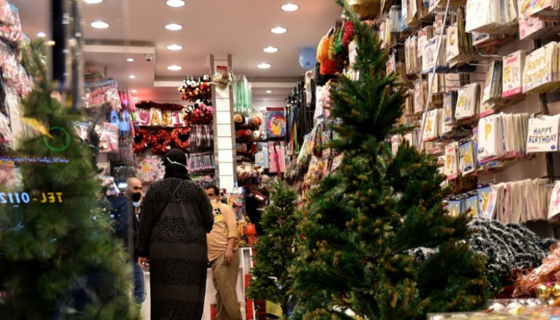 A file photo from December 7, 2020 shows people walking past Christmas decorations for sale at a gift shop in Riyadh. — AFP photo