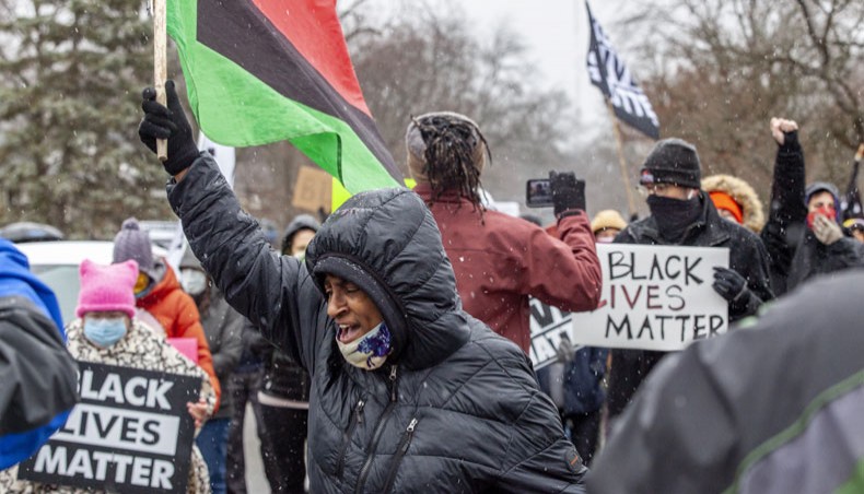 A protester chants as people hold Black Lives Matter signs during a demonstration against the police killing of Andre Hill in the neighborhood where Hill was shot, in Columbus, Ohio on December 24, 2020. – AFP Photo