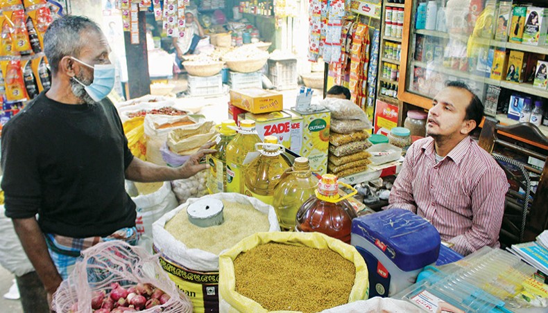 A shopkeeper sells various essential commodities, including rice and edible oil, at a grocery shop at Raysaheb Bazar kitchen market in the capital on Friday. — Focusbangla photo