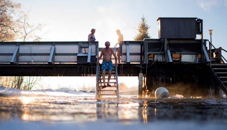 In this file photo taken on January 15, 2017, Finns take a dip in an unfrozen hole of water after a sauna session in Vaasa, as air temperature is -17°C and water is +1°C. —AFP Photo