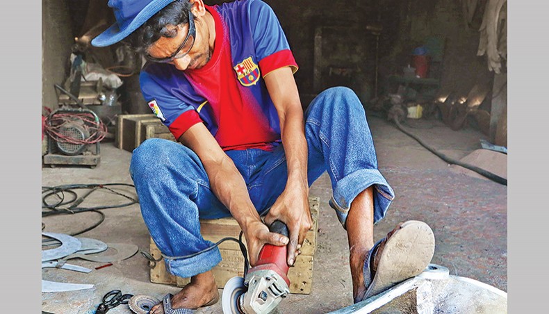 A file photo shows a man working at a light engineering factory in the capital. — New Age photo