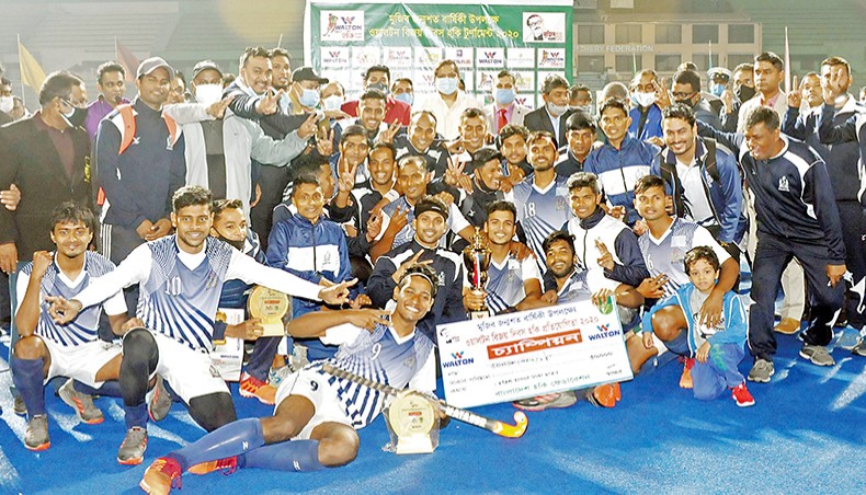 Bangladesh Navy players and official celebrate with the trophy after defeating Air Force in the Victory Day Hockey final at the Maulana Bhashani National Hockey Stadium on Sunday. — Courtesy photo