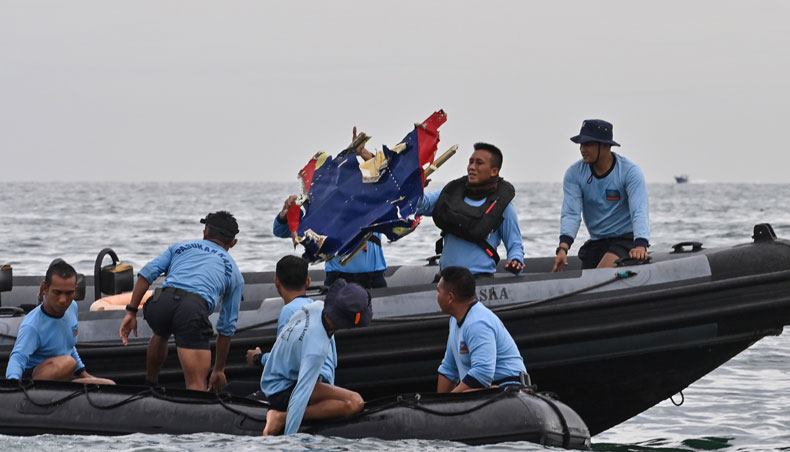 Indonesian Navy divers hold wreckage from Sriwijaya Air flight SJY182 during a search and rescue operation at sea near Lancang island on January 10, 2021, after the Boeing 737-500 crashed shortly after taking off from Jakarta airport on January 9. — AFP photo