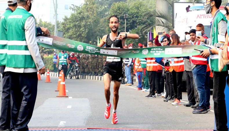 Morocco’s Hicham Laqouahi touches the finishing line to win the marathon in elite group of the Bangabandhu Sheikh Mujib Dhaka Marathon at Hatirjheel on Sunday. — Courtesy photo