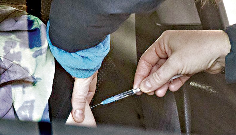 A woman getting vaccinated at a drive-through COVID-19 vaccination centre in Manchester. — PA Images/PA Wire/Peter Byrne