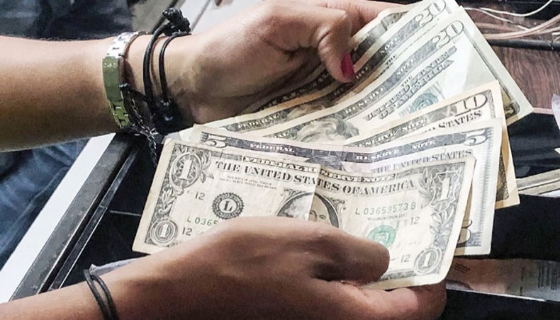 A file photo shows a cashier counting dollar bills at a restaurant. The US economy saw little inflation in 2020 amid the disruptions caused by the coronavirus pandemic, with the final month of a year seeing only a slight increase as gasoline prices rose, according to government data Wednesday. — AFP photo