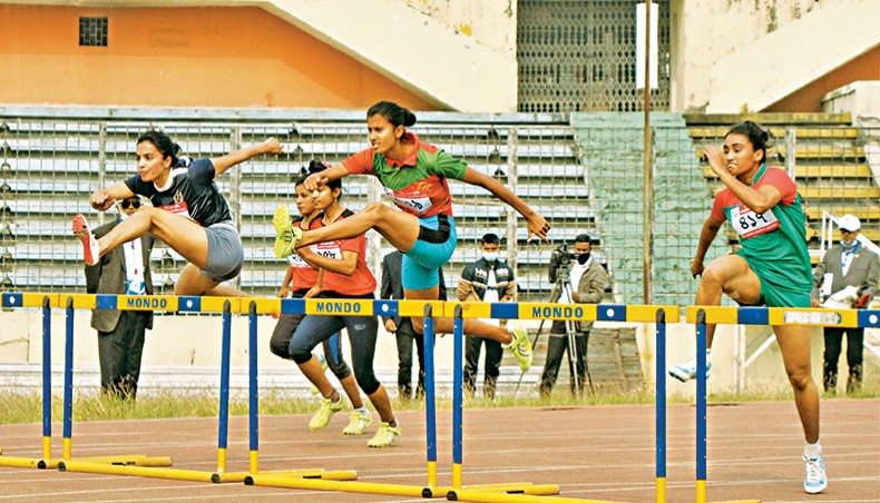 Tamanna Akter (L) of Bangladesh Navy competes in the women’s 100-metre hurdles of the 44th National Athletics Championships at the BNS on Saturday. — New Age photo