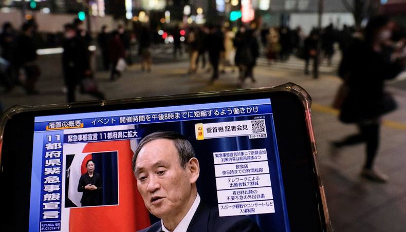 Japanese prime minister Yoshihide Suga is seen on a mobile phone screen during his live press conference at Tokyo’s Shinjuku district on January 13, 2021 under a state of emergency over the COVID-19 pandemic. — AFP photo