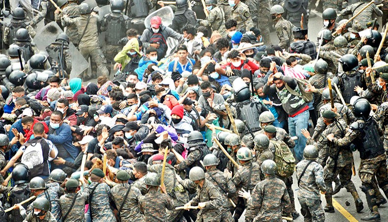 Honduran migrants, part of a caravan heading to the United States, clash with Guatemalan security forces in Vado Hondo, Guatemala on Sunday. Guatemalan police fired tear gas Sunday to try to disperse a caravan of thousands of migrants heading toward the United States. — AFP photo
