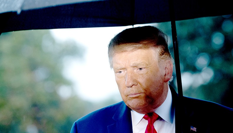 In this file photo, US president Donald Trump holds an umbrella as he speaks to the media under the rain prior to departing from the South Lawn of the White House in Washington, DC, on September 17, 2020. — Agence France-Presse/Saul Loeb