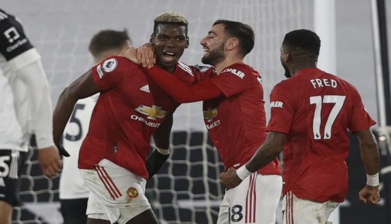 Manchester United's French midfielder Paul Pogba (L) celebrates with Manchester United's Portuguese midfielder Bruno Fernandes (2R) after scoring their second goal to take the lead 1-2 during the English Premier League football match between Fulham and Manchester United at Craven Cottage in London on January 20, 2021.- AFP photo