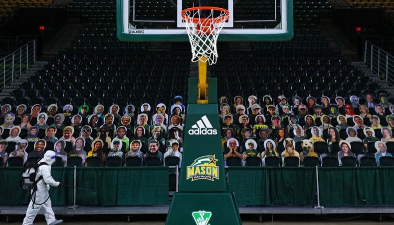 Cardboard cutouts of fans are seen as Alexander Espinoza of V and G cleaning services uses an electromagnetic sanitiser with hospital-grade disinfectant to sterilize the George Mason Patriots men's basketball court against the novel coronavirus. -- AFP photo