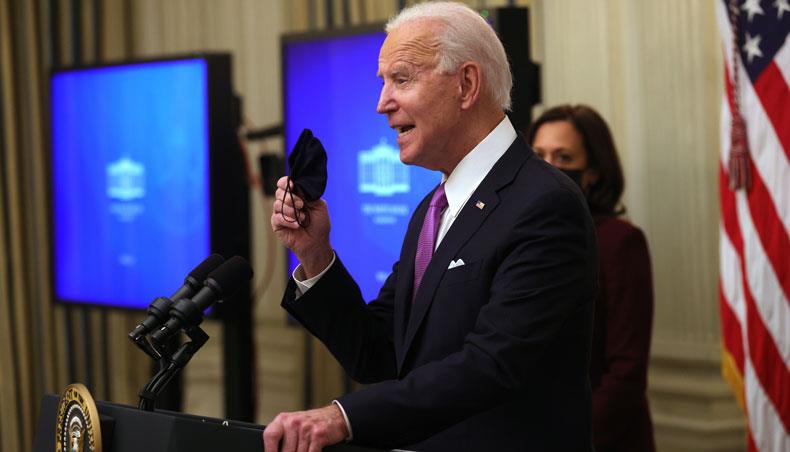US president Joe Biden holds up a mask as vice-president Kamala Harris looks on during an event at the State Dining Room of the White House January 21, 2021 in Washington, DC. — AFP photo