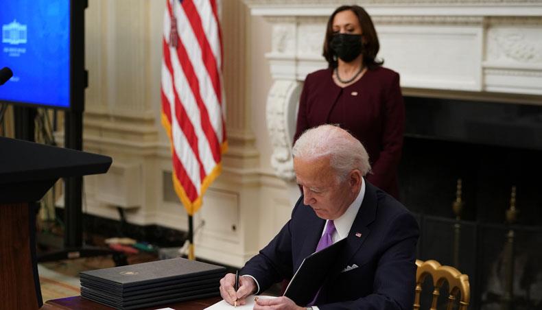 US president Joe Biden signs an executive order promoting safe travel as part of the COVID-19 response in the State Dining Room of the White House in Washington, DC, on January 21, 2021. — AFP photo