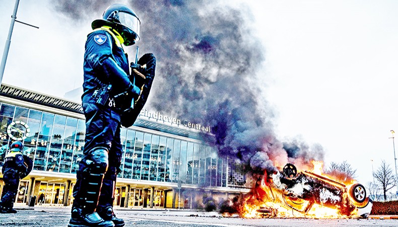 A car has been set on fire in front of the train station, on Saturday in Eindhoven, after a rally by several hundreds of people against the corona policy. — AFP photo