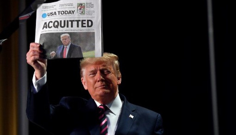 In this file photo taken on February 06, 2020, US president Donald Trump holds up a newspaper that displays a headline 'acquitted' as he arrives to speak at the 68th annual National Prayer Breakfast in Washington, DC.- AFP photo
