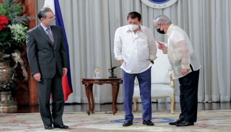 This handout photo taken on January 16, 2021 and received from the Presidential Photo Department (PPD) on January 17 shows Philippine president Rodrigo Duterte (C) listening to Philippine foreign secretary Teodoro Locsin (R) as they welcome China's foreign minister Wang Yi (L) during a courtesy call at the Malacanang Palace in Manila.- AFP photo