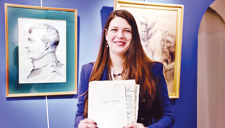 Alizee Raux, daugter of collector of French imperial memorabilia and ‘Arts et autographes’ gallery owner Jean-Emmanuel Raux, poses with Napoleon Bonaparte’s account of his victory during the Battle of Austerlitz, on January 25, 2021. — AFP photo