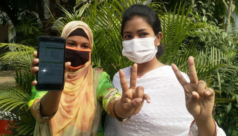 Two HSC examinees of Siddeshwari Girls’ College show victory sign after getting their results on mobile phone on Saturday. — Sony Ramany