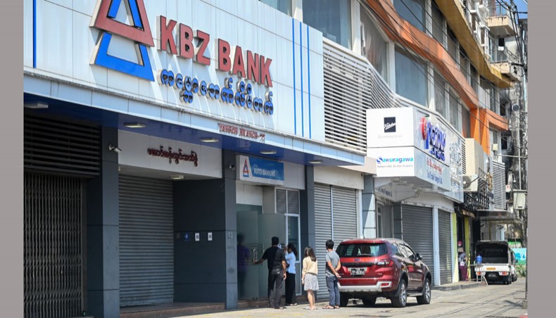 People line up at an ATM outside a closed branch of KBZ Bank in Yangon on February 1, 2021, as banks closed for the day in Myanmar following the military move to detain the country’s de facto leader Aung San Suu Kyi and the president in a coup. — AFP Photo