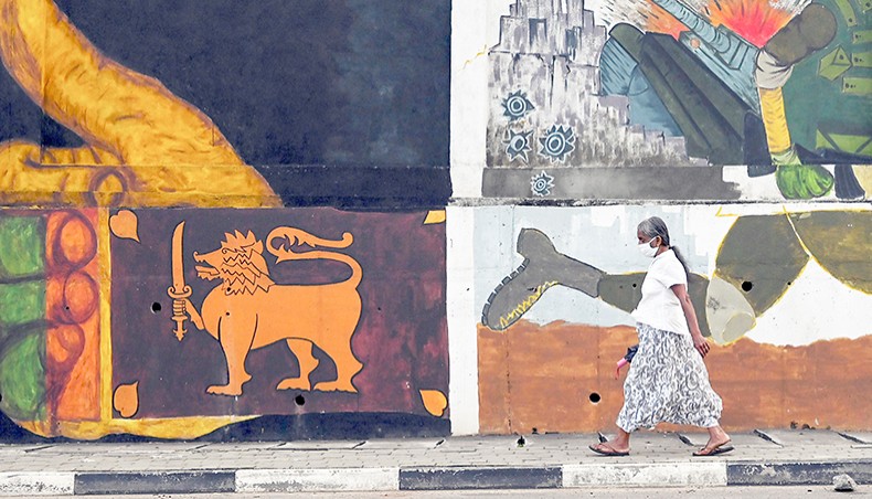 A woman walks past a mural in Colombo on January 26. — Agence France-Presse/Lakruwan Wanniarachchi