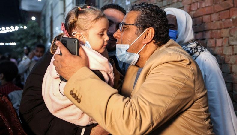 Mahmoud Hussein, an Egyptian national and senior journalist for Qatar-based Al Jazeera Arabic, kisses a child upon his arrival at his family home in the Giza village of Zawyet Abu Musallam, about 30 kilometres south of Egypt's capital Cairo on February 6, 2021 upon his release from detention. -- AFP photo