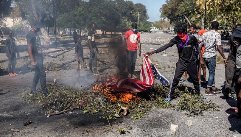Demonstrators burn an American flag on February 7, 2021 in Port-au-Prince, Haiti during a protest to demand the resignation of president Jovenel Moïse, who seeks to extend his term of office until February 2022, which according to the constitution ends this February 7. — AFP photo