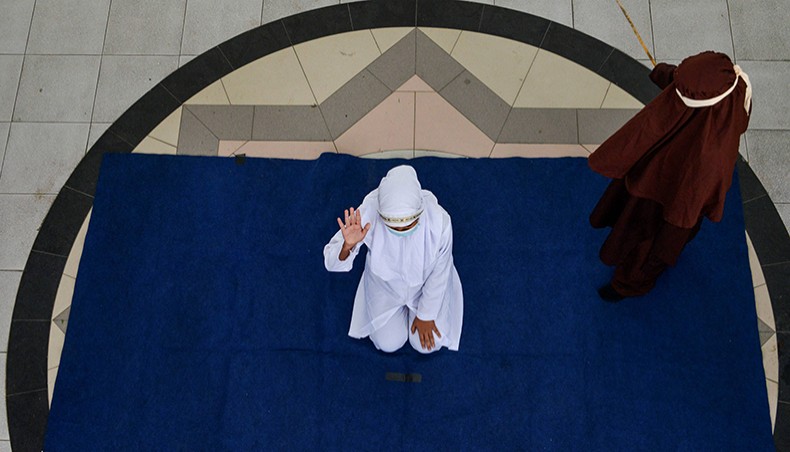 A woman reacts while being publicly caned by a member of the Sharia police after she was caught in close proximity with her boylfriend in Banda Aceh on February 8, 2021. — AFP Photo