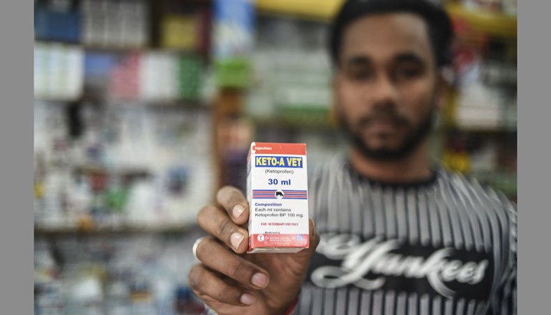 A salesman shows a box containing Ketoprofen medicine at a drugstore on the outskirts of Dhaka on February 9, 2021. — AFP Photo