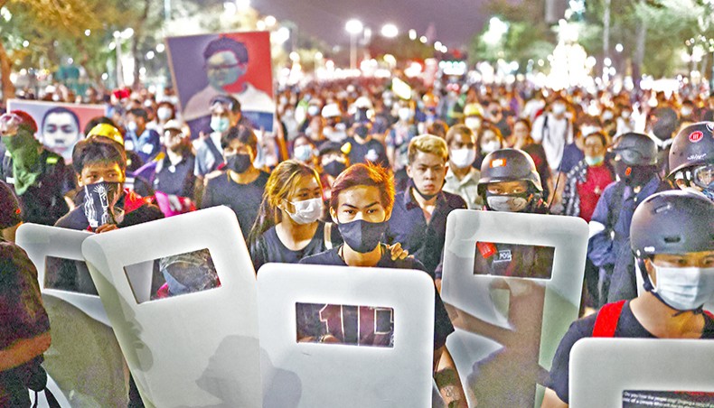 Pro-democracy protesters carry shields as they march during an anti-government rally in Bangkok on Saturday. — AFP photo