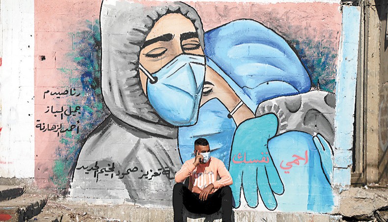 A man sits in front of a mural at the Nusseirat refugee camp in the central Gaza Strip in November, 2020. — Consortium News/Ashraf Amra