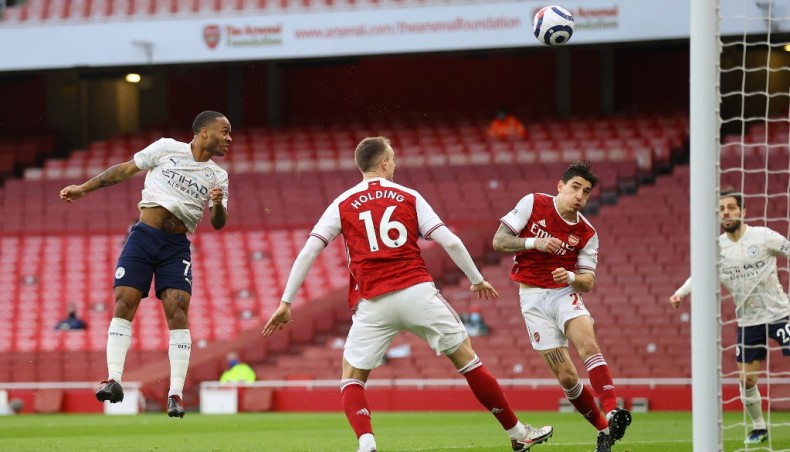 Manchester City midfielder Raheem Sterling (L) heads to score against Arsenal during their Premier League match at the Emirates Stadium in London on Sunday.— AFP photo